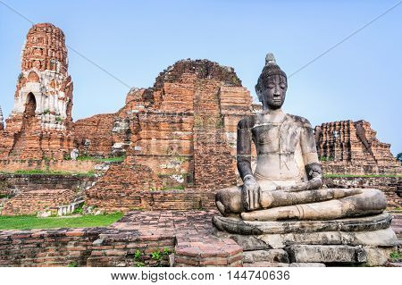 Ancient ruins of pagoda and old buddha statue at Wat Phra Mahathat temple is a famous attractions in Phra Nakhon Si Ayutthaya Historical Park Thailand