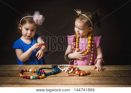 young and cute little girls play with jewelry