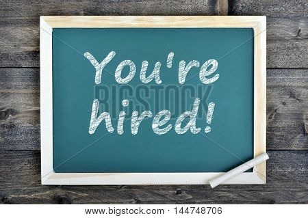 You're hired text on school board and chalk on wooden table