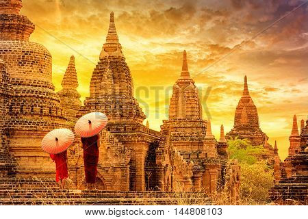 Novice monk with red umbrella walking around ba-gan Pagoda Ba gan Myanmar.