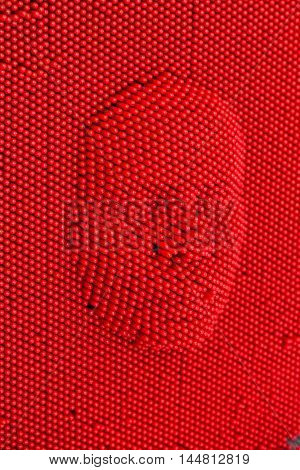 Face pressed to red pin art board