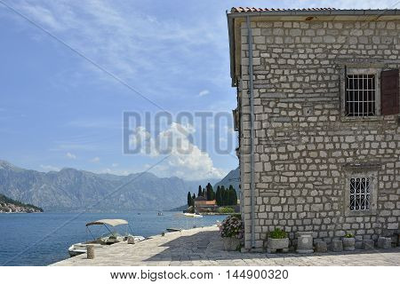 The Our Lady of the Rock island in Kotor Bay Montenegro. The island was artificially created by locals using rocks. The small island of St George's Abbey can be seen in the background