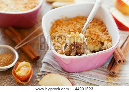 Apple crumble with cinnamon on rustic wooden table. Sweet dessert.