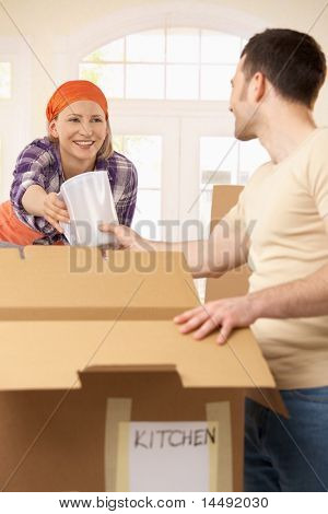 Šťastná žena předání vybavení kuchyně na kluka sbalit.?