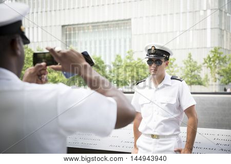 NEW YORK MAY 27 2016: A Canadian sailor serving on the Moncton 708 has his picture taken at the reflecting pools at One World Trade on the National September 11 Memorial site during Fleet Week 2016.