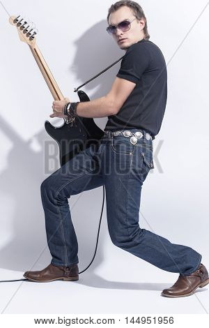 Music Concepts. Handsome Male Guitarist Posing With Guitar Against White. Vertical Image