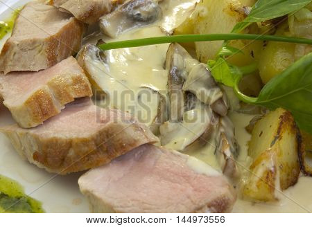 meat in sauce with potatoes and vegetables on a white background
