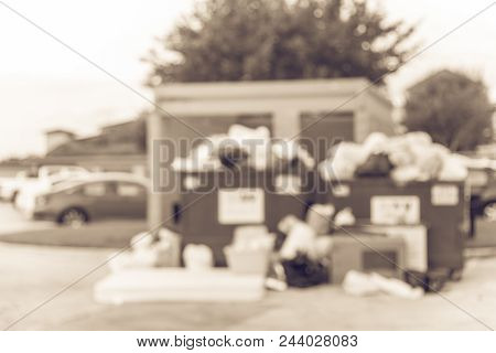 Vintage Blurred Overflowing Dumpster At Apartment Building In Usa