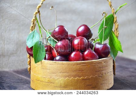 Fresh Cherries In Basket On Wooden Table