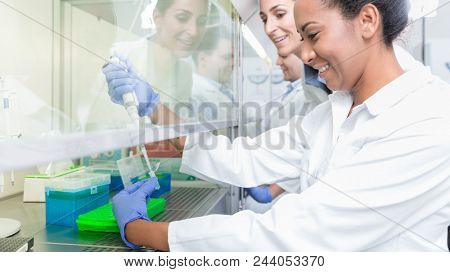 Group of scientists in research laboratory working under splashback
