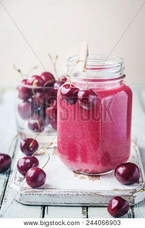 Healthy Cherry Smoothie With Frozen Strawberry, Coconat Water And Honey In Glass On White Wooden Tab