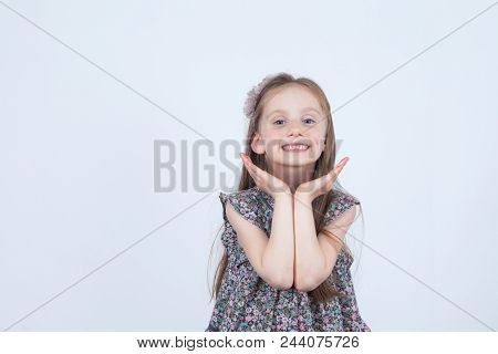 Little Girl Is Making Faces. Funny And Happy Expressions. Having Fun. Preschooler In Dress On White 