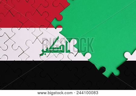 Iraq Flag  Is Depicted On A Completed Jigsaw Puzzle With Free Green Copy Space On The Right Side.