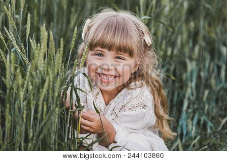 Happy Little Girl On Green Wheat Field