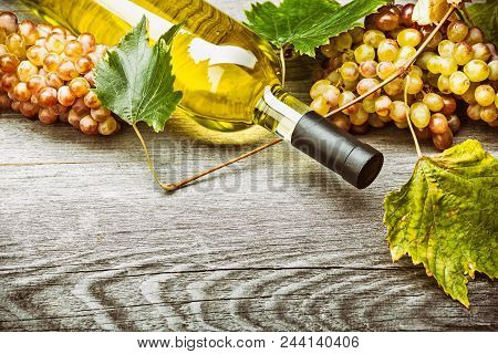 White Wine In A Glass With Fall Grapes, Old Wooden Background