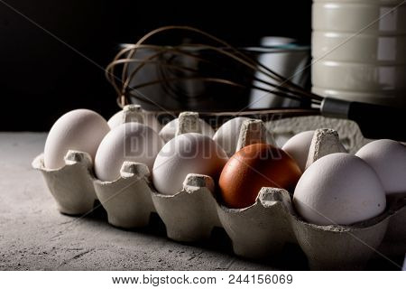 Close-up View Of Raw Chicken Eggs In Egg Box In Front Of Milk In The Bottle, Bowl, Mixer. Copyspace.