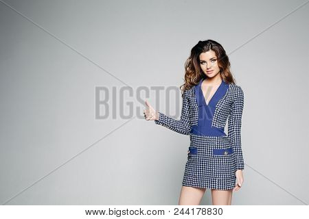 Smiling Attractive Brunette Woman In Short Dress In Cage Posing With Hand On Down And Showing Thumbs