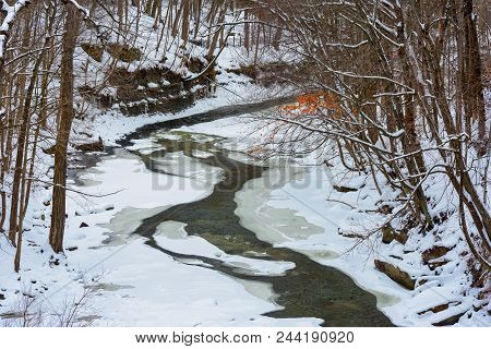 The Chagrin River Cuts A Narrow Channel Through Ice And Snow Below The Falls In Chagrin Falls, Ohio