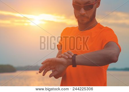 Checking The Time After Exercising / Jogging Outdoors. Optical Focus Is On The Hand And Watch.
