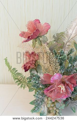 Artificial Flowers On An Expensive Chest Of Drawers.