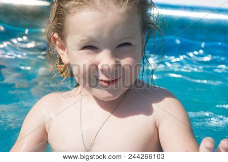 The Girl Smiles, Looks Into The Frame, Squints From The Sun, The Child Is Pleased With The Bathing A