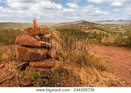 Cairn Built On Top Of A Hill Under A Cloudy Sky Next To A Footpath With A View Into The Distance In 