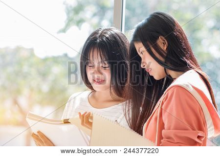Asian University Or College Students Studying Together With Tablet And Documents Paper For Report Ne