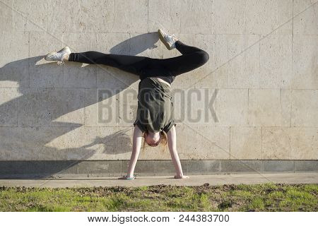 Young Female Handstand Against The Wall Performs Acrobatic Elements, Close Up