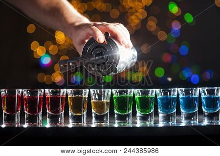 Bartender Pouring Alcoholic Drink Into Small Glasses On Bar. Colorful Cocktails At The Bar.