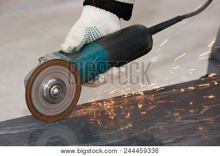 The Hand Of A Worker In A Glove Cuts The Building Material With An Angular Grinding Machine, Creatin