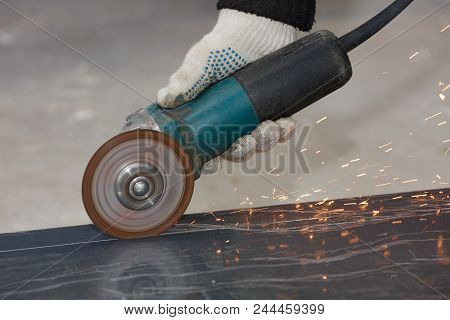 The Hand Of A Worker In A Glove Cuts The Building Material With An Angular Grinding Machine, Creatin