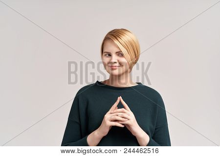 Headshot Of Cunning Beautiful Woman With Straight Dyed Hair Looking Aside Holding Hand Under Chin In