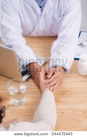 Friendly Doctor Hands Holding Patient Hand Sitting At The Desk For Encouragement, Empathy, Cheering