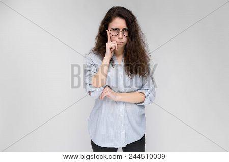 Young Girl With Glasses On A Gray Background. Portrait Of A Young Beautiful Girl. A Charming Girl In