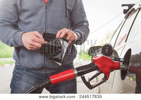 Lack Of Money For Gasoline And Fuel. Expensive Gasoline. Driver Man Holds One Dollar End Empty Walle