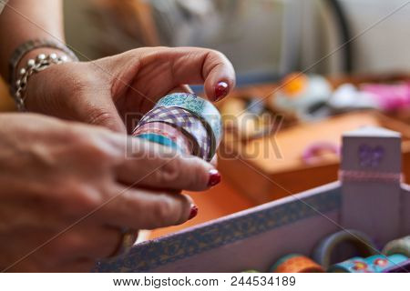 Hands Manipulating Washi Tape Collection In Multiple Designs