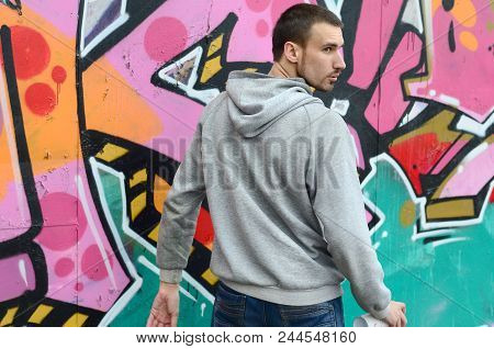 A Young Graffiti Artist Looks Around While Drawing. Vandal Tries To Be Undetected While Drawing The 
