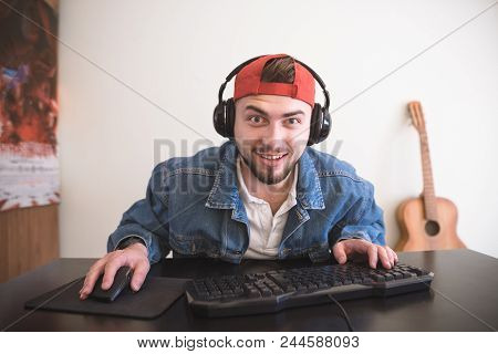Adult Gamer Looks At The Computer Monitor With Astonished Face. A Surprised Man Plays Video Games At