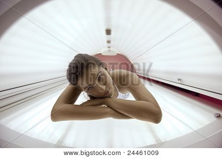 Belle jeune femme ont le traitement de la peau en solarium moderne de bronzage