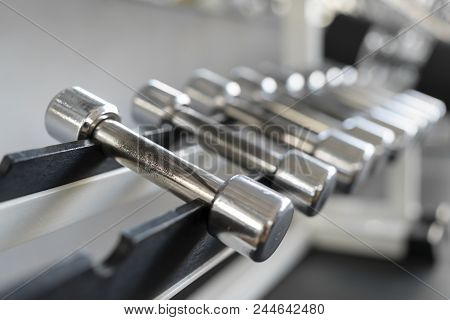 Rows Of Dumbbells In The Gym With Hign Contrast Light