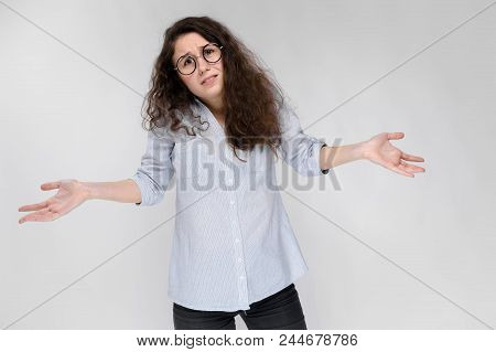 Young Girl With Glasses On A Gray Background. Portrait Of A Young Beautiful Girl. A Charming Girl In