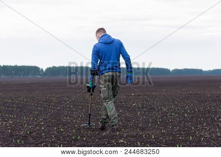 Man To Seek Treasure On Earth With A Metal Detector, Walks The Field, Squeak Gold