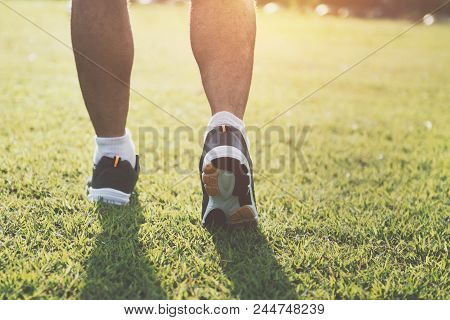 Close Up Runer Leg  Running On Grass With Sunset At Park