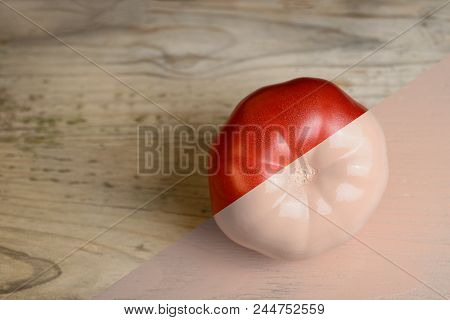 Natural Red And Beige Or Ecru Half Painted Tomato On Wooden Background
