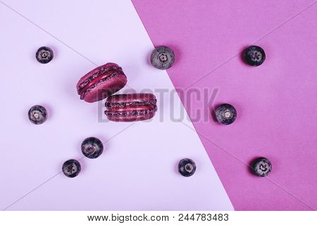 Two Purple Macarons On Ultra Violet Background With Blueberries. Flat Lay Style.
