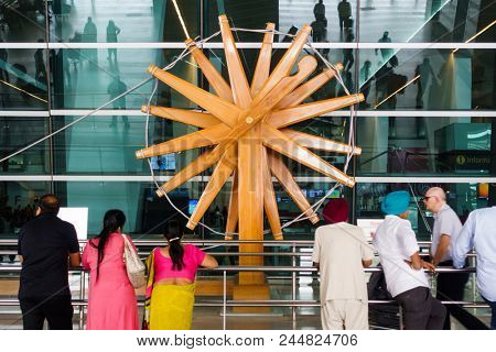 NEW DELHI, INDIA - CIRCA APRIL 2017: People stand in front of the world's largest charkha (spinning wheel) at Indira Gandhi International Airport.