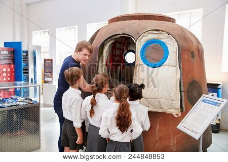 Kids and teacher look at a space capsule at a science centre