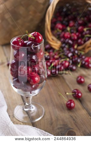 A Lot Of Ripe And Sweet Cherries, On The Table And In A Glass, For Traditional Belgian Beer. Delicio