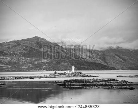 Isle Ornsay With White Tower Of Lighthouse; Isle Of Skye; Scotland. Sunny Winter Day With Snowy Moun