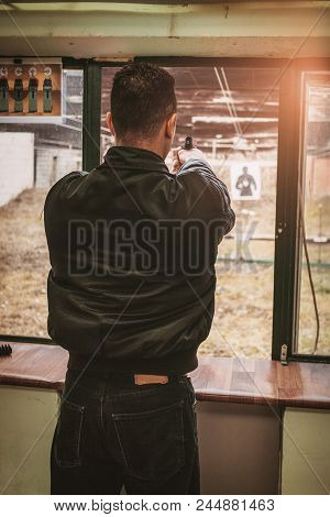 Man Firing With Pistol On Target At The Shooting Range. Close-up.